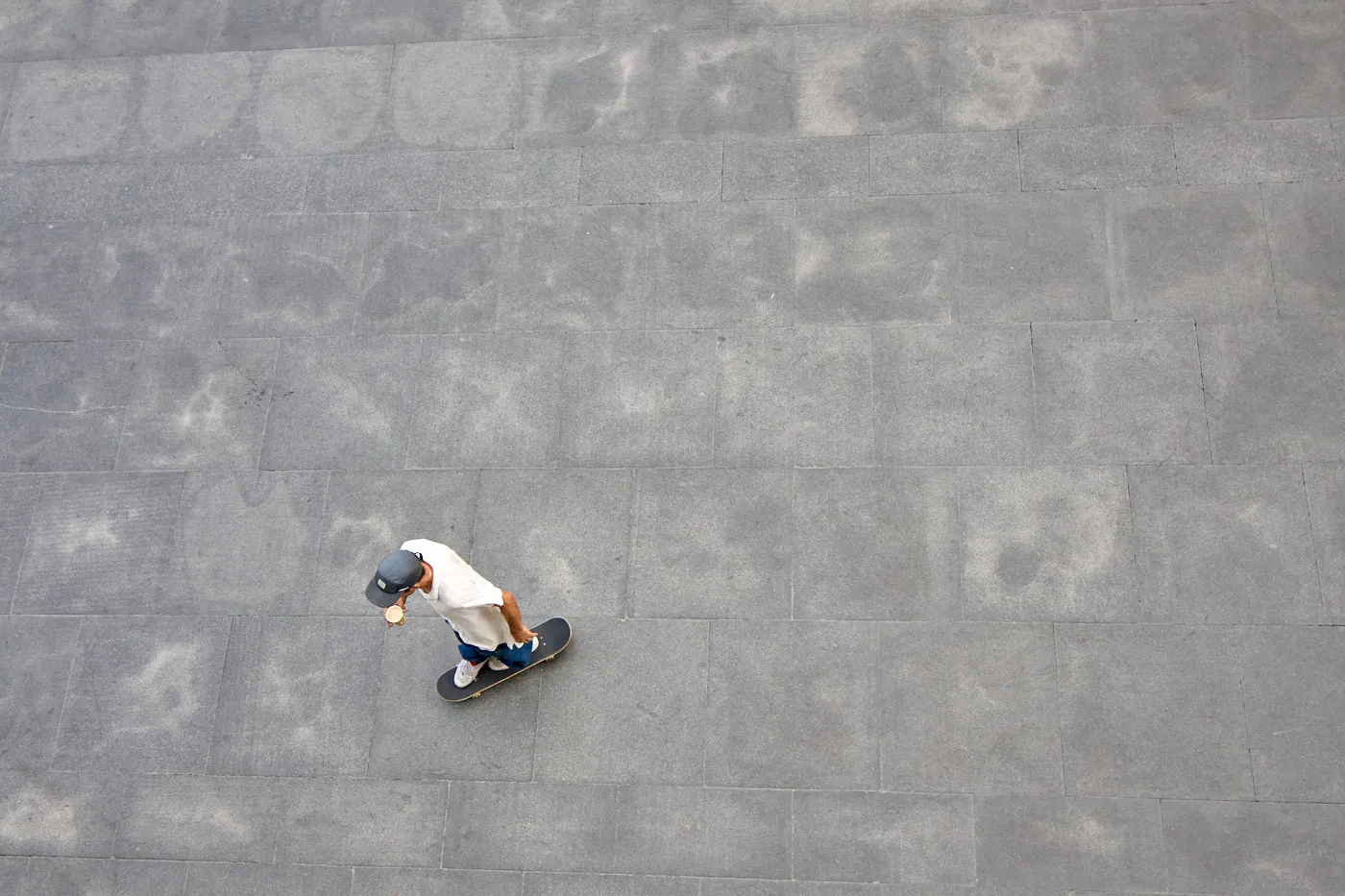 Skater from above grey plaza